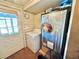 Cozy laundry room with washer, wooden walls, and an exterior door with a window for natural light at 4075 Packard Ave, St Cloud, FL 34772