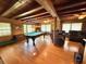 Open living area with a pool table, hardwood floors, beamed ceilings, and ample natural light at 4075 Packard Ave, St Cloud, FL 34772