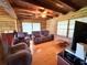 Warm living room with log accents, hardwood floors, ceiling beams, and comfortable seating area at 4075 Packard Ave, St Cloud, FL 34772