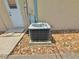 Close-up of the property's AC unit, set upon a concrete base, surrounded by decorative stones, next to the back door at 4125 Packard Ave, St Cloud, FL 34772
