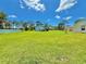 Spacious green backyard with a white garage-like building in the distance and blue skies at 4125 Packard Ave, St Cloud, FL 34772
