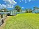 The backyard features a storage shed and a large grassy area enclosed by a white vinyl fence at 4125 Packard Ave, St Cloud, FL 34772