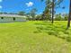 Sprawling green backyard features scattered trees, blue skies, and the side of the house at 4125 Packard Ave, St Cloud, FL 34772
