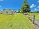 Expansive backyard featuring lush green grass, a wooden fence and scattered trees at 4125 Packard Ave, St Cloud, FL 34772
