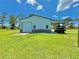 Exterior shot of metal garage with open car port on green lawn against bright blue partly cloudy sky at 4125 Packard Ave, St Cloud, FL 34772