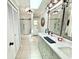 Bathroom featuring a skylight, double vanity, and subway-tiled shower with glass doors at 4125 Packard Ave, St Cloud, FL 34772