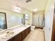 Well-lit bathroom featuring a double sink vanity and shower with a neutral-toned curtain at 4125 Packard Ave, St Cloud, FL 34772
