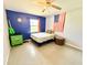 Bedroom with ceiling fan, blue accent wall, guitar, and American flag at 4125 Packard Ave, St Cloud, FL 34772