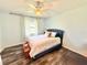 Bright bedroom featuring wood-look floors, a ceiling fan, and modern curtains at 4125 Packard Ave, St Cloud, FL 34772