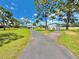 Long driveway leading to a charming property with a well-maintained yard, garage, and lush landscaping at 4125 Packard Ave, St Cloud, FL 34772