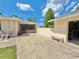 Backyard view featuring a spacious patio, detached garage, and a lovely outdoor seating area at 4125 Packard Ave, St Cloud, FL 34772