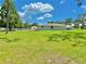 Side exterior shot of house and detached garages on spacious property with lush green grass at 4125 Packard Ave, St Cloud, FL 34772