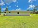 Exterior view of the house with green lawn on a sunny day with blue sky and white clouds at 4125 Packard Ave, St Cloud, FL 34772
