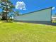 Steel building with a gray trim is situated on a green lawn, framed by a partly cloudy bright sky at 4125 Packard Ave, St Cloud, FL 34772