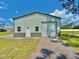 Steel garage with a gray trim, a white door, two windows, set against a clear blue sky and green grass at 4125 Packard Ave, St Cloud, FL 34772