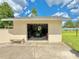 View of a detached garage with a lawn mower inside and a concrete bench outside at 4125 Packard Ave, St Cloud, FL 34772