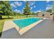 The clear swimming pool features a metal ladder for easy access and a clean, paved patio, adjacent to a grassy lawn at 4125 Packard Ave, St Cloud, FL 34772