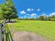 Lush green pasture enclosed by fences and scattered with mature trees under a blue sky at 4125 Packard Ave, St Cloud, FL 34772