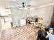 A room with wood-look flooring, ceiling fan, and a view to the bright, adjacent kitchen at 4125 Packard Ave, St Cloud, FL 34772