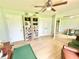 Relaxing green room showcasing a built-in bookshelf and natural light from a large window at 4125 Packard Ave, St Cloud, FL 34772