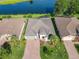An aerial shot showcases the brick driveway, manicured lawn, and lake view at 418 Treviso Dr, Kissimmee, FL 34759
