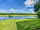 View of the backyard showing lush lawn and lake at 418 Treviso Dr, Kissimmee, FL 34759