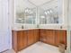 Bright bathroom featuring double sinks, wood cabinets, large mirrors, and modern lighting at 418 Treviso Dr, Kissimmee, FL 34759