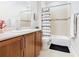 Bright bathroom with a wood cabinet, white countertop, and a shower with stylish, patterned curtain at 418 Treviso Dr, Kissimmee, FL 34759