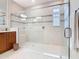Bright bathroom featuring wood vanity, large frameless shower, and neutral tile at 418 Treviso Dr, Kissimmee, FL 34759