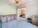 View into a carpeted bedroom with boxes, tan walls, modern lighting, and a sneak peek of a furnished bedroom beyond at 418 Treviso Dr, Kissimmee, FL 34759