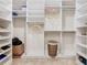 Spacious walk-in closet with custom shelving, hanging rods, ample storage and a built-in laundry basket at 418 Treviso Dr, Kissimmee, FL 34759