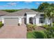 A beautiful home featuring a paved driveway, two-car garage, and manicured landscaping at 418 Treviso Dr, Kissimmee, FL 34759