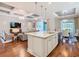 Kitchen island with seating, sink, and stainless steel appliances, opens to living and dining areas at 418 Treviso Dr, Kissimmee, FL 34759