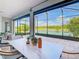 Enclosed lanai with a dining table, chairs, and a view of the lush backyard and serene lake at 418 Treviso Dr, Kissimmee, FL 34759