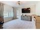 Bright living room featuring neutral walls, plush carpeting, modern light fixture, and a media center below the television at 418 Treviso Dr, Kissimmee, FL 34759