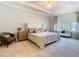 Relaxing main bedroom suite showcasing a cozy sitting area, large window and stylish chandelier at 418 Treviso Dr, Kissimmee, FL 34759