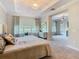Bright main bedroom featuring a tray ceiling, a chandelier, and a serene view at 418 Treviso Dr, Kissimmee, FL 34759