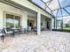 Expansive outdoor patio featuring stone flooring, a dining table, and a screened-in lanai at 418 Treviso Dr, Kissimmee, FL 34759