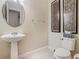 Classic powder room features a pedestal sink, stylish wallpaper, decorative art, and a toilet at 418 Treviso Dr, Kissimmee, FL 34759