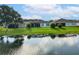 Rear exterior view of homes with well-maintained lawns and waterfront access at 418 Treviso Dr, Kissimmee, FL 34759