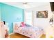 A bedroom with blue accent wall, pink bedspread, natural light, and decorated with items at 423 Midway Ave, Mascotte, FL 34753