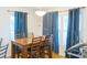 A charming dining room with a wooden table, upholstered chairs, and windows with elegant curtains at 423 Midway Ave, Mascotte, FL 34753
