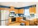 A kitchen featuring stainless steel appliances, blue walls, wooden cabinets, and a cozy breakfast bar at 423 Midway Ave, Mascotte, FL 34753