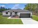 New construction home features a two-car garage, stylish accents, verdant lawn, and easy-to-maintain landscaping at 4528 Sw 149Th St, Ocala, FL 34473
