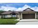 Home exterior showcasing a well-kept lawn, and two-car garage under a sunny sky at 4830 Red Bay Dr, Orlando, FL 32829