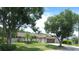 Landscaped home exterior featuring a well-kept lawn and mature trees under a blue sky at 4830 Red Bay Dr, Orlando, FL 32829