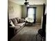 Comfortable bedroom with neutral carpet, a window, and a cozy papasan chair at 5519 Braken Fern Way, Leesburg, FL 34748