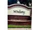 Windsong brick community sign, with a quaint look and manicured greenery, welcoming residents and guests at 5519 Braken Fern Way, Leesburg, FL 34748