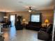 Open concept living space with tile flooring, a ceiling fan, and sliding glass doors to the outside at 5519 Braken Fern Way, Leesburg, FL 34748