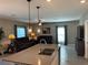 Open concept living space featuring tile flooring, modern lighting fixtures, and comfortable seating at 5519 Braken Fern Way, Leesburg, FL 34748